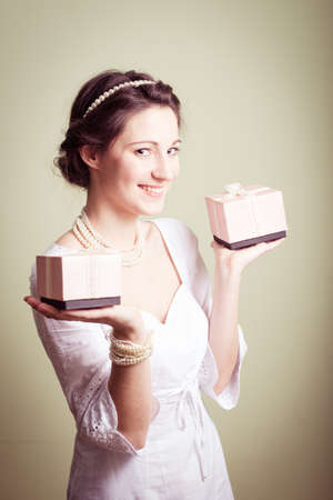 portrait of holding present boxes up elegant beautiful young lady in white dress having fun happy smile on copy space backgroundの写真素材
