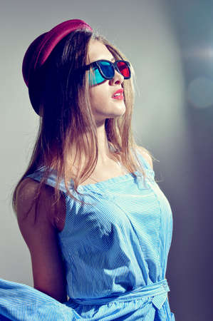 Portrait of young pretty lady in 3d glasses and bowler hat thoughtfully looking forward at copy spaceの写真素材