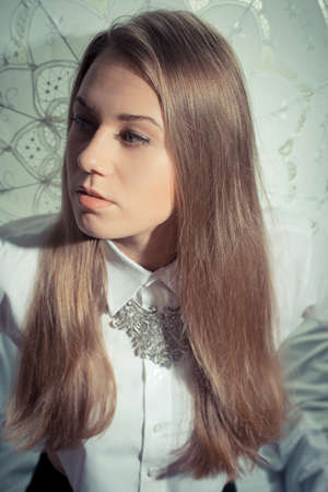 Blonde pretty girl in a white shirt over lace parasol backgroundの写真素材