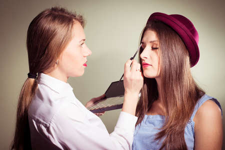 Girl doing another girl makeupの写真素材
