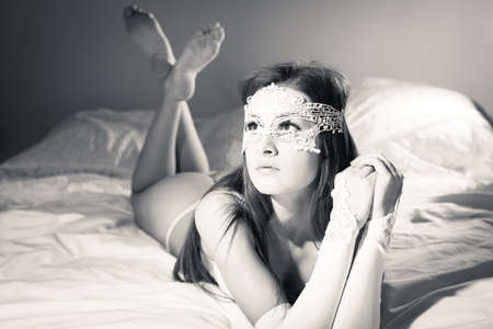 close up picture of beautiful young lady in lingerie relaxing in bed, black and whiteの写真素材