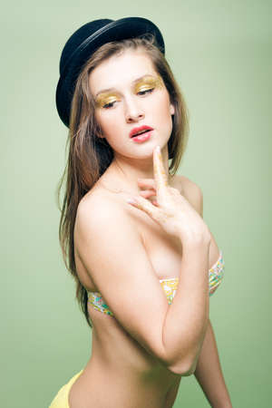 Portrait of romantic sexy young lady having fun in lingerie sensually touching lips with finger on copy space backgroundの写真素材