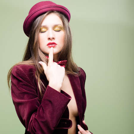 Portrait of romantic sexy beautiful young lady in bowler hat and yellow underwear with bare breasts and stomach on copy space backgroundの写真素材