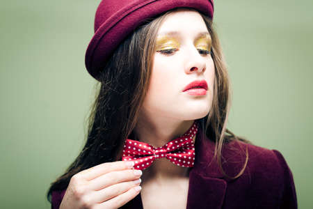 Portrait of romantic sexy beautiful young lady in bowler hat and bow tie with shining makeupの写真素材