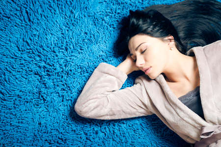 Portrait of beautiful luxury girl having fun relaxing sleeping on blue carpet copy space backgroundの写真素材