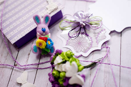 Picture of artistic handmade rabbit, gift box and decorations on wooden table background