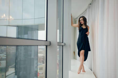 Portrait of beautiful young woman having fun relaxing looking out the windowの写真素材