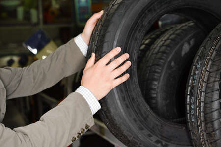 Picture closeup on hands choosing a tire or tyre