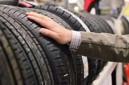 Picture closeup on hands choosing a tire