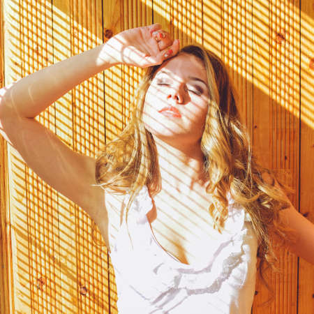 Closeup portrait of young pretty lady having fun happy relaxing over wooden backgroundの写真素材