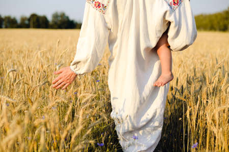Mother and child walking in the wheat fieldの写真素材