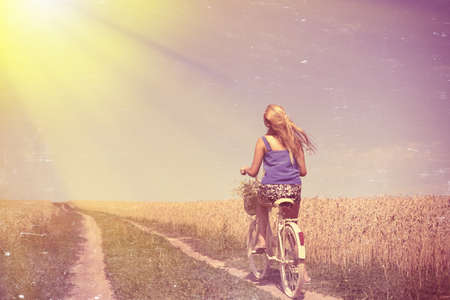 Image of pretty female travel with cycle on the wheat field outdoors background copy spaceの写真素材