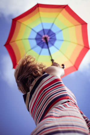 Image of elegant romantic woman having fun holding up umbrella on blue sky copy space backgroundの写真素材