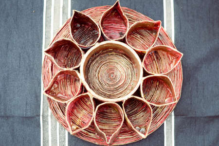 Picture of lotus flower like candle holder. Top view of stylish red toned art object on striped indoor background.の写真素材