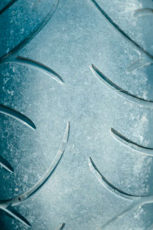 Picture of motorcycle tire pattern. Closeup of black used rubber with round shaped lines.