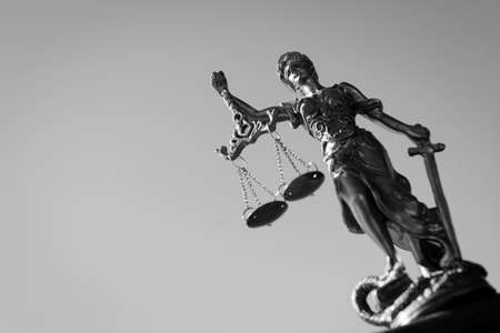 Black and white photography of themis sculpture, femida or justice goddess on bright sky backgroundの写真素材