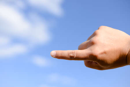 Picture of pointing hand up to sky on sunny outdoors copy space backroundの写真素材