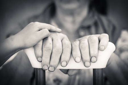 Close up picture on senior and young person hands holding crutch. Black and white photographyの写真素材