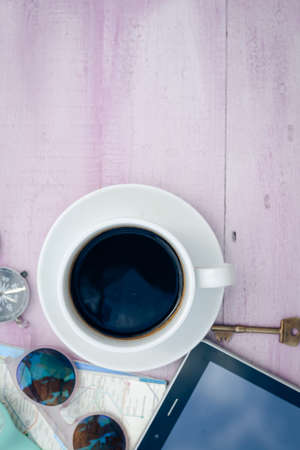 Copyspace picture of cup of coffee and tablet pc, key, sunglasses as symbol of  relaxed lifestyle