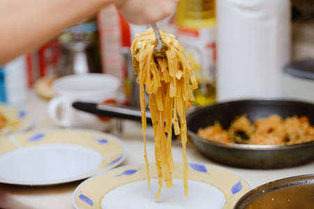 Closeup photo of delicious noodles with seafood cooked in metal panの写真素材