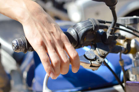 Closeup on rider's hand on the handlebar on sunny background