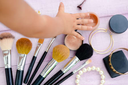 Top view of child hand with make up bruches on the table background, flat lay style closeupの写真素材