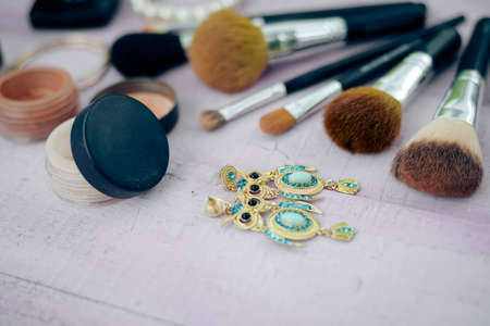Flat lay of brushes and cosmetic on a table background. Top view closeup