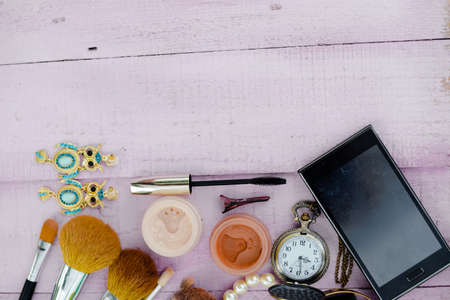 Flat lay of brushes and cosmetic set and mobile phone on a table background. Top view closeupの写真素材
