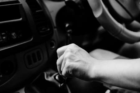 UK right hand drive car. black white photography driver closeup hand changing gear, background dashboardの写真素材