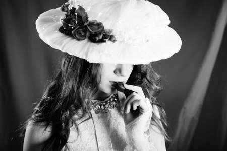Black and white photography of beautiful young lady eating chocolate, closeup
