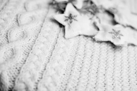 Black and white photography of woolen knitted sweater with star decorations. Concept of winter time, top viewの写真素材