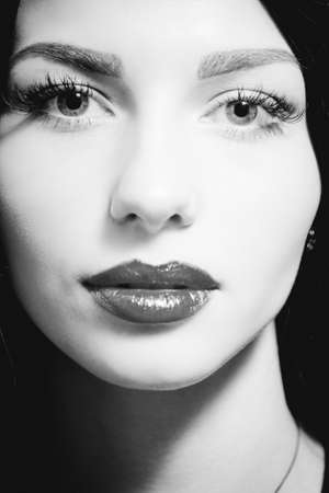 Black and white picture of gorgeous brunette woman. Beautiful face of young lady with bright lipsの写真素材