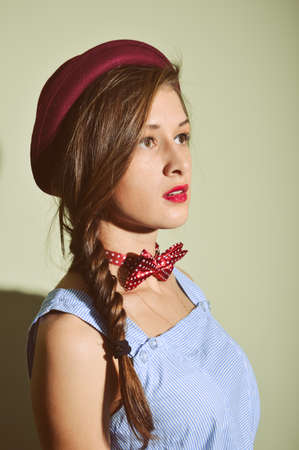 Closeup portrait of beautiful elegant young female with hat on light background indoorsの写真素材