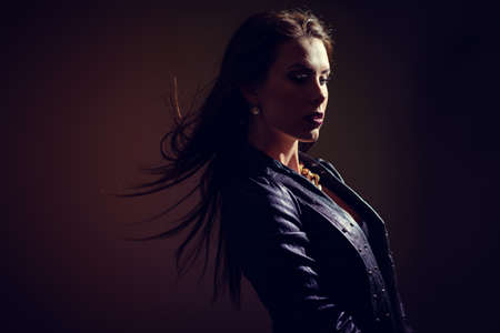 Beautiful stylish glamor woman in black leather jacket, studio shot on light background