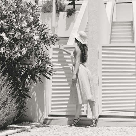 Back view of elegant woman walking, summer light outdoors background