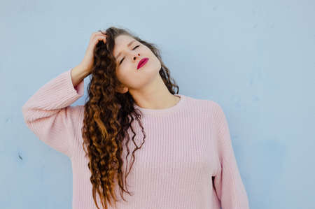 Joyful cheerful woman gesturing on light wall background
