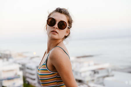 Pretty woman wearing sunglasses on holiday vacation backgroundの写真素材