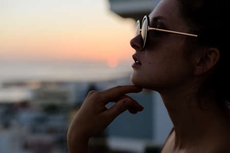 Pretty woman wearing sunglasses on holiday vacation backgroundの写真素材