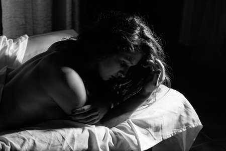 Attractive woman relaxing on the bedroom backgroundの写真素材