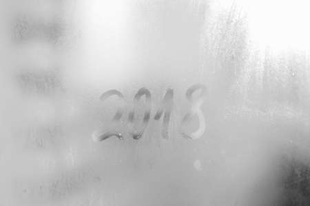 2018 painted on a misted glass window background. Close up photo of New Year drawの写真素材