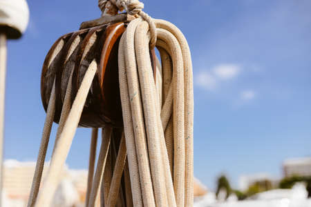 Closeup view of ship rope tackles on outdoors sunny blue sky backgroundの写真素材