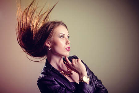 Portrait of beautiful glamorous woman in black leather jacket on light backgroundの写真素材