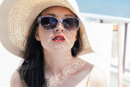Beautiful woman luxury relaxing enjoying sun on blue sky sea outdoors backgroundの写真素材