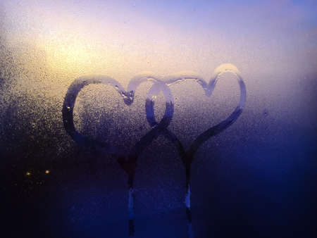 Blurry closeup on love heart sign inscription on condensation indoors glass texture backgroundの写真素材