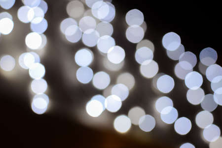 Blurry defocused festive glitter bokeh, shiny lights illumination texture backgroundの写真素材
