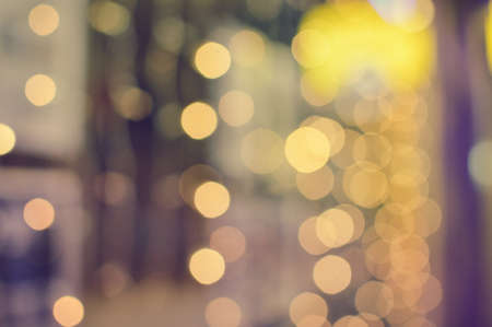 Blurry defocused festive glitter bokeh, shiny lights illumination texture backgroundの写真素材