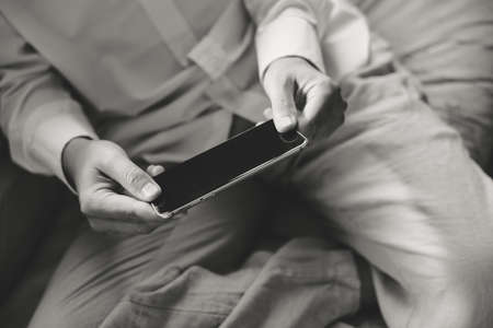 Top view close up of a man using mobile smart phone, mock up displayの写真素材
