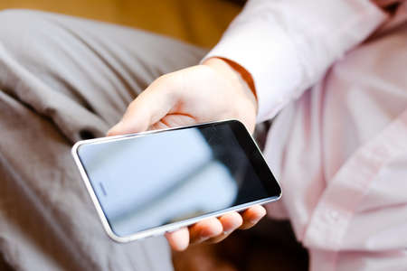 Top view close up of a man using mobile smart phone, mock up displayの写真素材