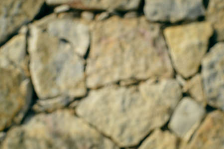 Blurred defocused stone wall textured backgroundの写真素材