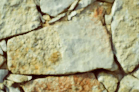 Blurred defocused stone wall textured backgroundの写真素材